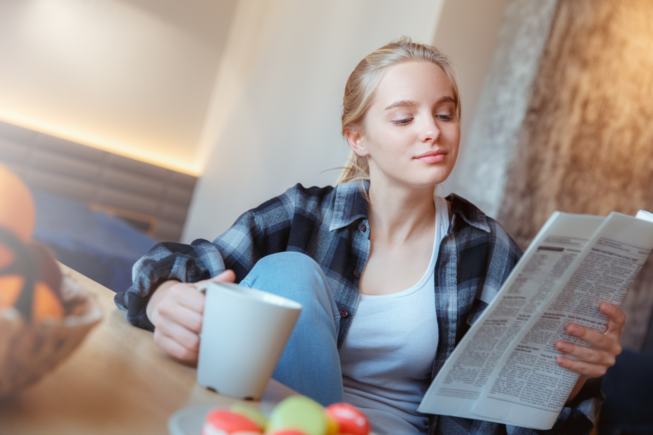 A woman enjoying a beverage while reading news