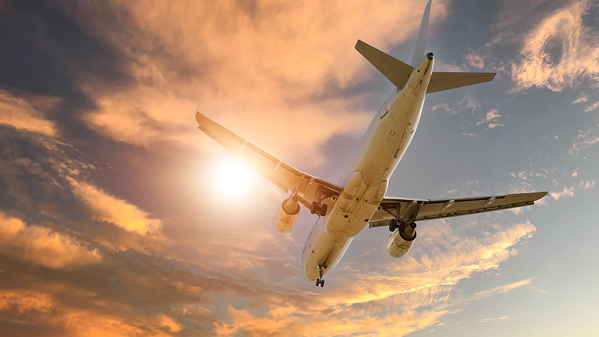 A plane using low carbon fuel flying with sun shining through A plane using low carbon fuel flying with sun shining through